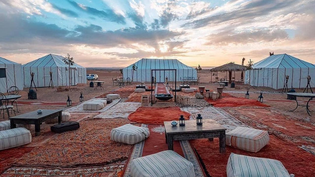 Les grandes dunes d'Erg Chegaga au coucher du soleil, un bivouac berbère installé en contrebas