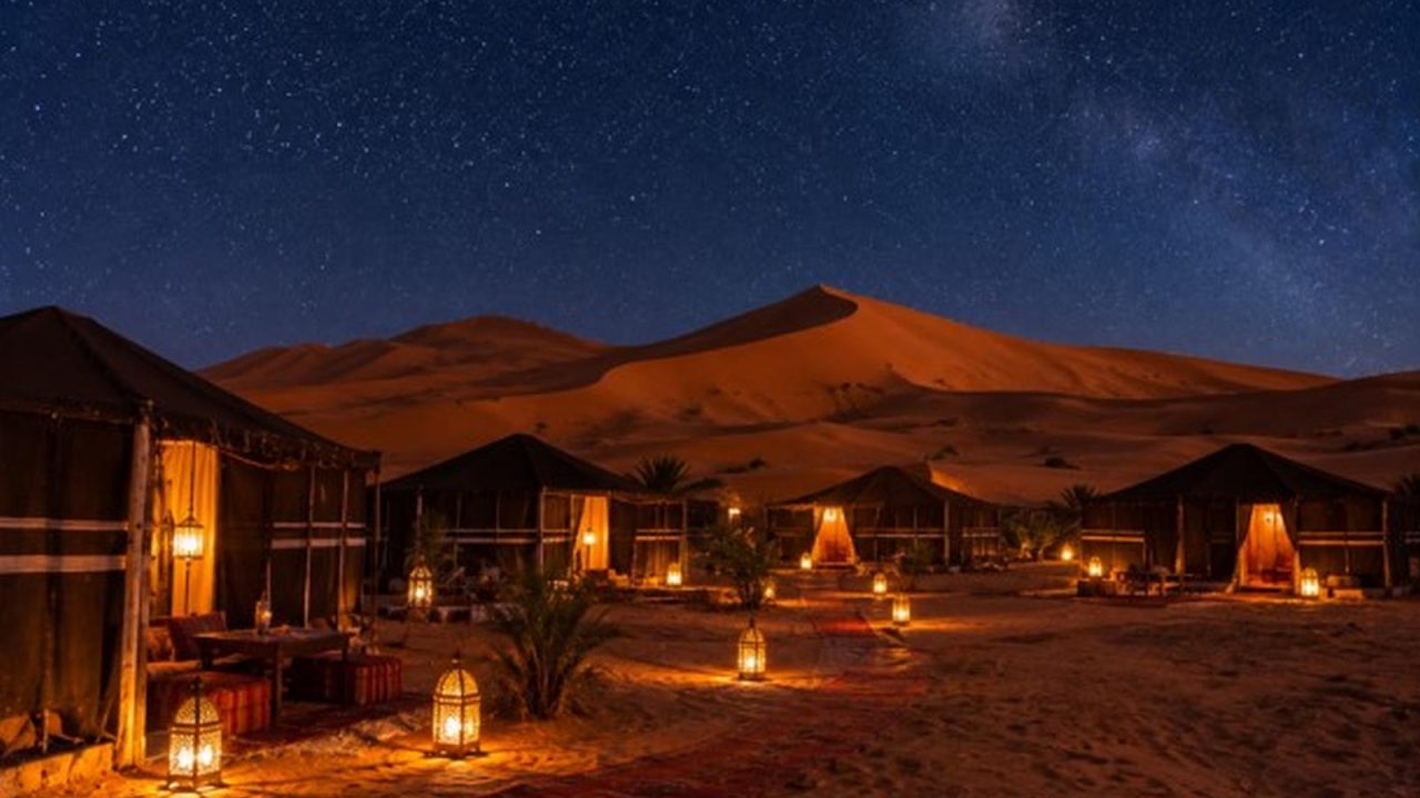 Berber desert camp tents at the foot of the Erg Chebbi dunes under a starry sky
