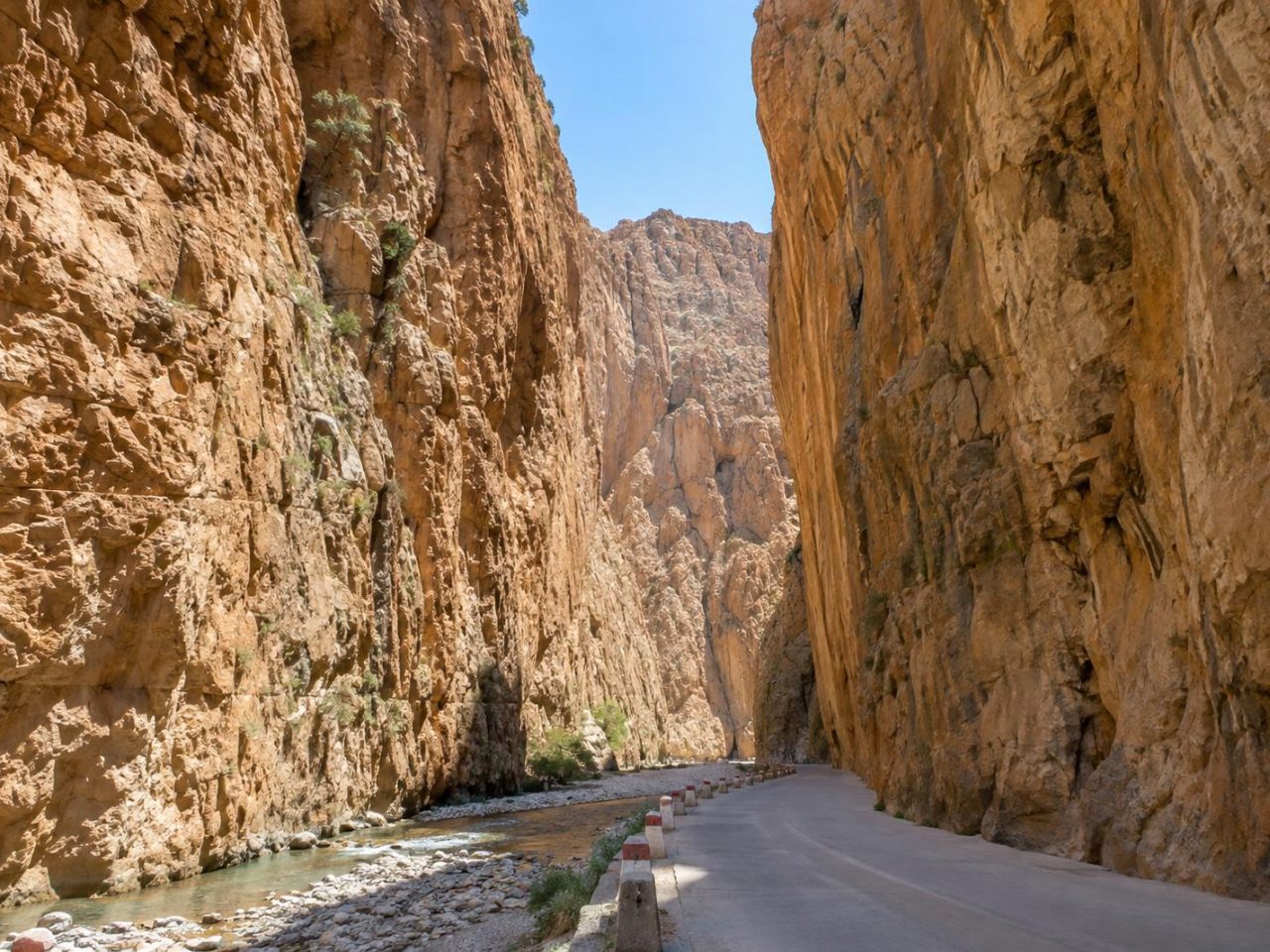 Sheer limestone walls of the Todra Gorge towering above the narrow canyon road