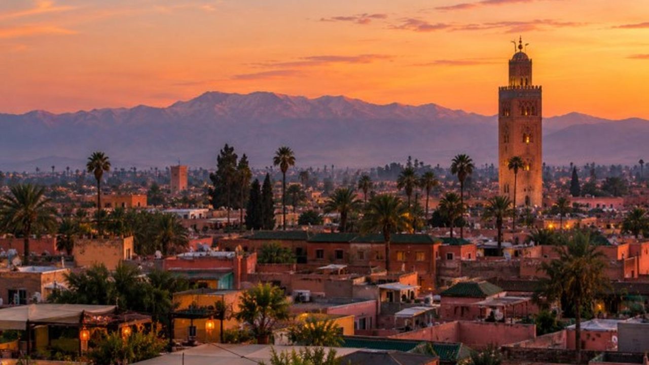 Toits et minaret de la médina de Marrakech au crépuscule, l'Atlas en arrière-plan