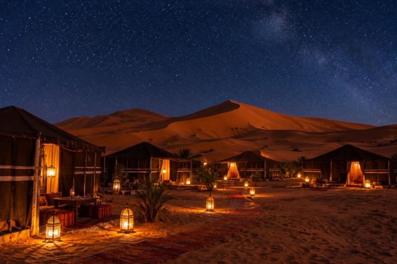 Berber desert camp tents at the foot of the Erg Chebbi dunes under a starry sky