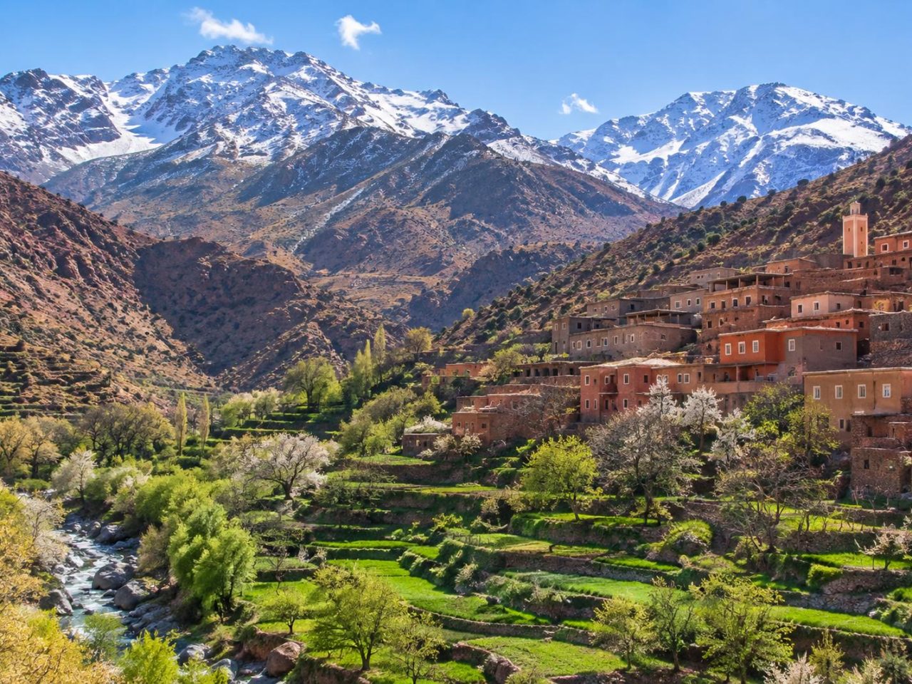 Terraced fields and a Berber village below snow-dusted High Atlas peaks