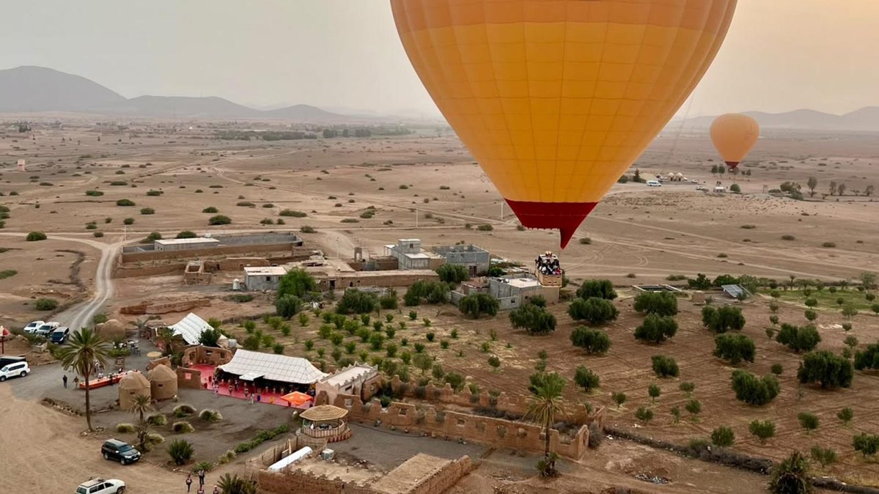 Montgolfière s'élevant au lever du soleil au-dessus des plaines au nord de Marrakech, l'Atlas en arrière-plan