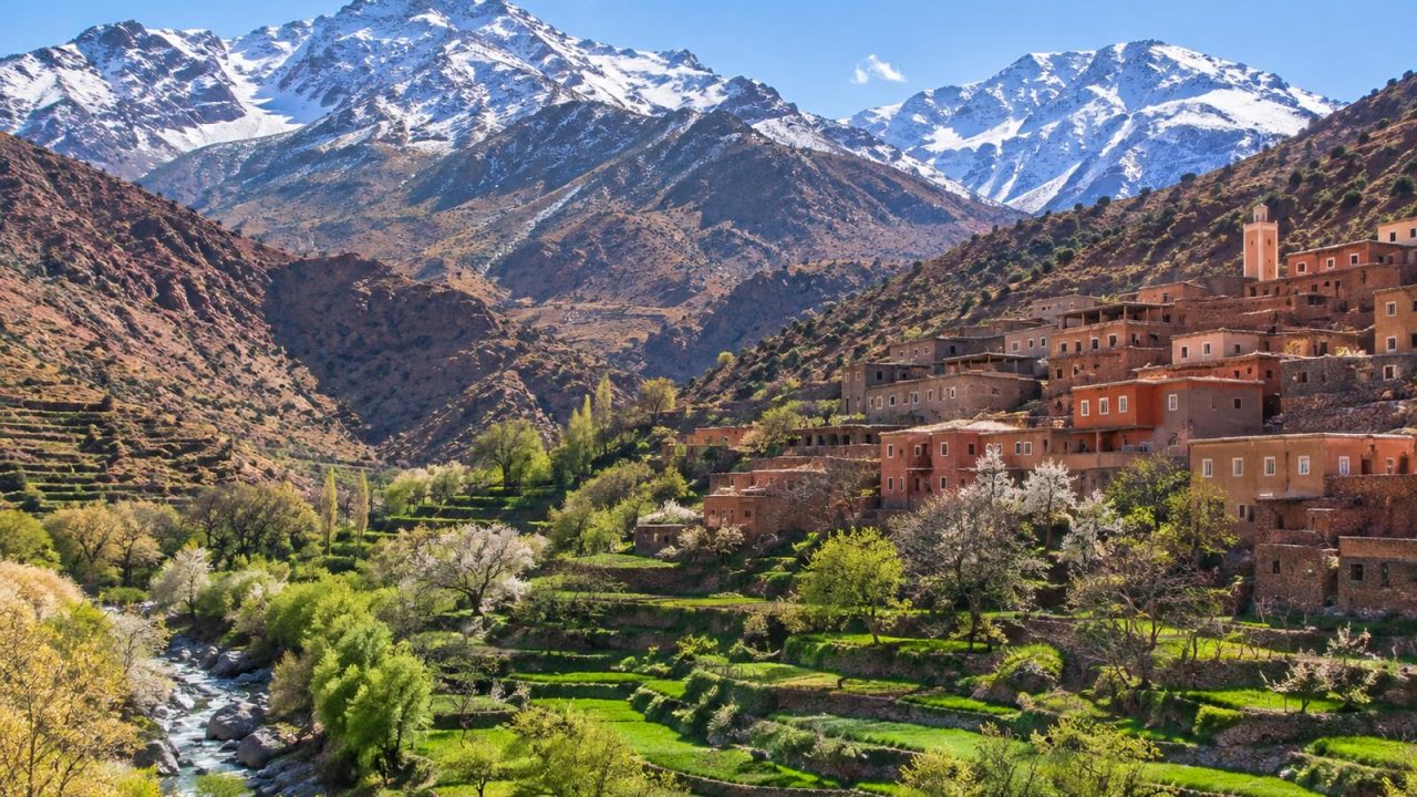 Terraced fields and a Berber village below snow-dusted High Atlas peaks